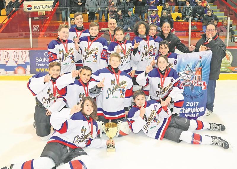Les joueurs et entraîneurs des Maskas posent fièrement avec le trophée et la bannière de champion.  Photo Robert Gosselin | Le Courrier ©