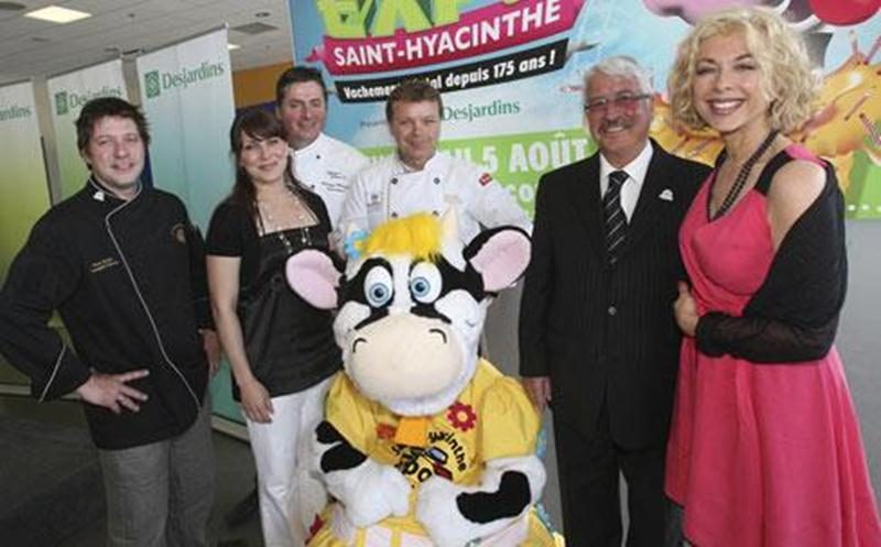 À gauche, les chefs Rock Fortin, Philippe Métayer et Thierry Maurer sont accompagnés de Geneviève Vouligny de Télé-Québec. À droite, le président d'honneur de l'Expo, Léon Sansoucy et la chanteuse et actrice Joe Bocan. Au centre, Mollie, la nouvelle mascotte de l'Expo.