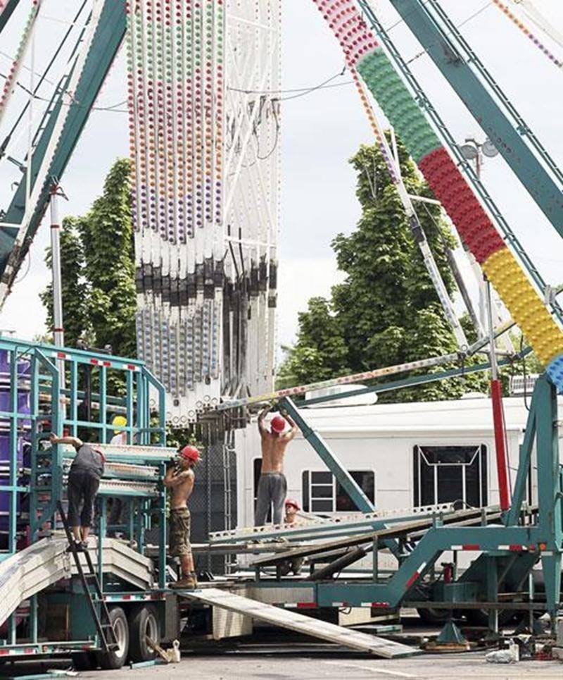 Des travailleurs s'affairent à monter sur le site de l'Expo l'imposant manège que représente la grande roue.
