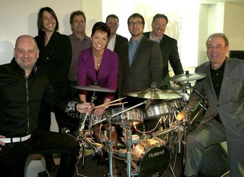 Sur la photo, de gauche à droite : Jean-François Poulin au chant, Marie-Claude Morin, présidente du conseil d'administration, Richard Bourret à la basse, Maryse Dubé au chant, Stéphane Tessier à la guitare, Martin Tessier, directeur général du Petit Pont, Jean-Denis Major à la batterie et Guy Duhaime au clavier.