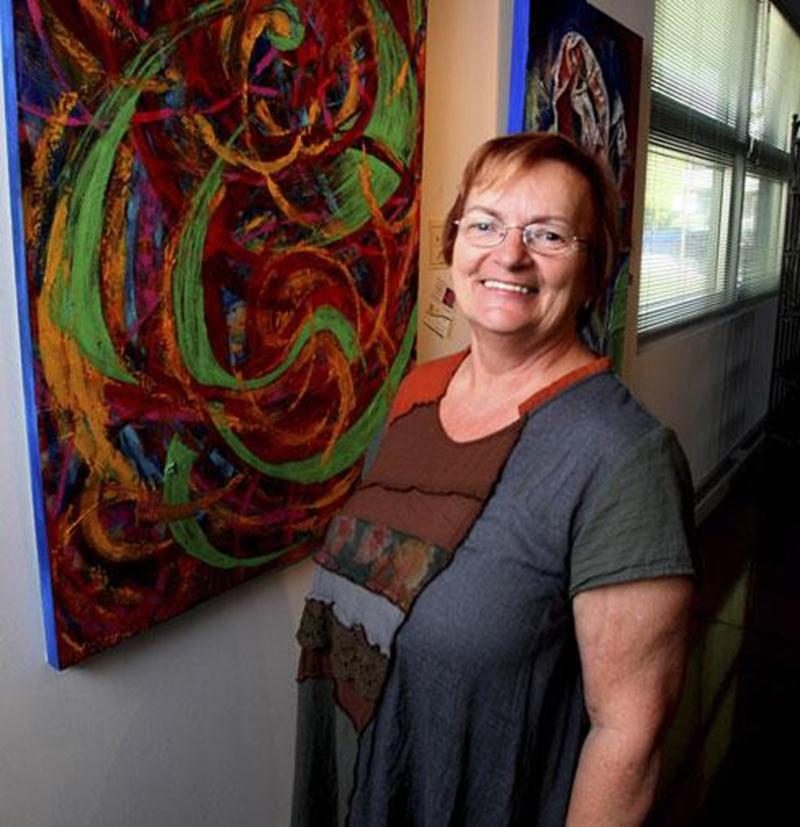 Maryse Laroche Plourde, présidente du conseil d'administration de Visit'art, présentant la toile <em>Jeux-2</em> qu'elle a réalisée à l'aide d'une spatule à cuisine.