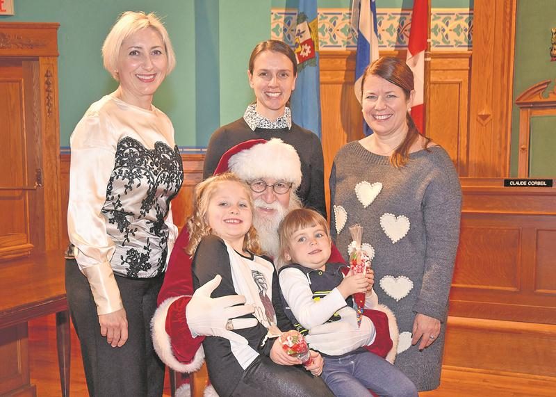 Le Père Noël espère qu’il y aura de la neige cette année lors de son défilé à Saint-Hyacinthe! Il est ici entouré de Caroline Nadeau, coordonnatrice par intérim de la Magie de Noël, de Christiane Di Lalla-Besner, travailleuse sociale à Grand Galop, de Caroline Dupré, présidente d’honneur de la Magie de Noël, et de jeunes filles qui attendent patiemment le 10 décembre!  Photo François Larivière | Le Courrier ©