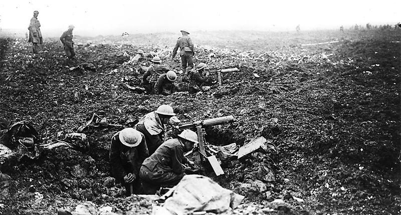Des artilleurs canadiens se protègent à l’aide de fissures dans le sol causées par des éclats d’obus sur la crête de Vimy en France, avril 1917.  Photo : Bibliothèque et Archives Canada PA-001017