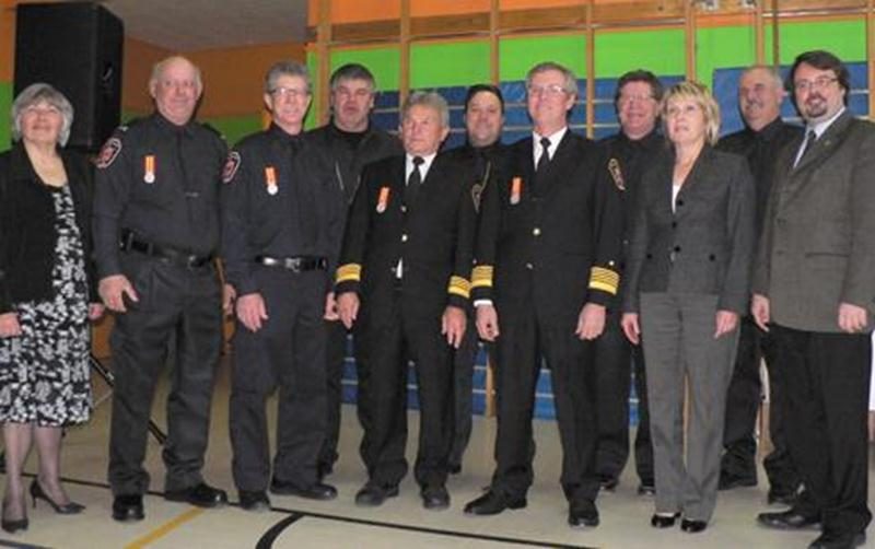 Les administrateurs de la Régie posent avec les récipiendaires de la médaille. De gauche à droite, première rangée : Doris Gosselin, vice-présidente; Jacques Mathieu et Denis Desrosiers, lieutenants; Richard Lambert, assistant-chef; Christian Desrosiers, chef; Maria Libert, vice-présidente; et Denis Marion, président. Deuxième rangée : les pompiers Denis Benoit, René Bonin, Yves Desrosiers et Alain Gauthier.