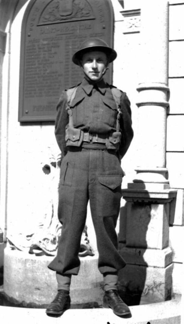 Un étudiant en costume militaire. Gaétan Bédard en habits militaires estivaux devant la porte des Maires en avril 1945 (collection Grégoire Girard).