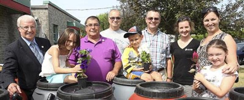 Dans le cadre de ses initiatives environnementales, la Ville de Saint-Pie s'est vue remettre, par le biais du Fonds Éco IGA, une subvention matérielle de 70 barils récupérateurs d'eau de pluie. La distribution de ces barils s'est effectuée le 3 juillet au terrain des loisirs de Saint-Pie. Les citoyens ont de plus reçu une fleur annuelle dans un petit pot préparé par les enfants du camp de jour. Sur la photo, de gauche à droite : Émilien Pelletier, député de Saint-Hyacinthe; Pierre St-Onge, maire