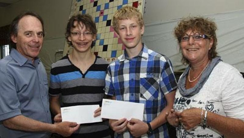 D r Carole Marois remettant une bourse de 150 $ à Charles-Émile Fecteau et Étienne Bilodeau, aux côtés de Lucie Dion, directrice à la commission des jeunes de la Fédération québécoise des clubs de Scrabble francophone lors d'une activité de financement au Centre communautaire Aquinois.