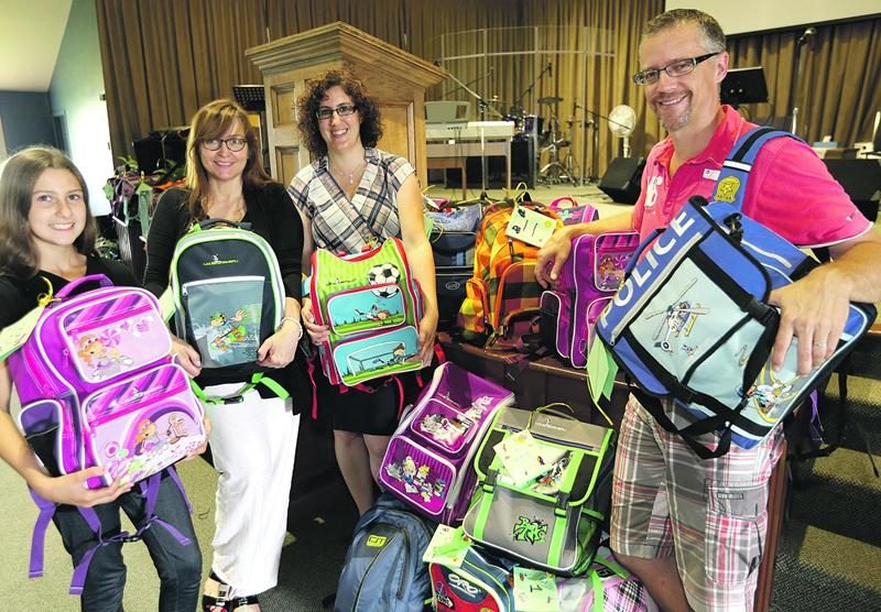 Anouk Royer, Josianne Charbonneau, Ketsia Bergeron ainsi que le Pasteur Guy Gosselin sont réunis fièrement devant leur accomplissement; la distribution s’est déroulée le 20 août. Photo Robert Gosselin | Le Courrier ©