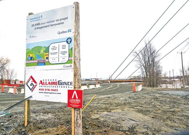 Un panneau d’affichage indiquant le financement du futur tunnel ferroviaire du boulevard Casavant Ouest est installé sur le chantier des travaux de construction.    Photo François Larivière | Le Courrier ©
