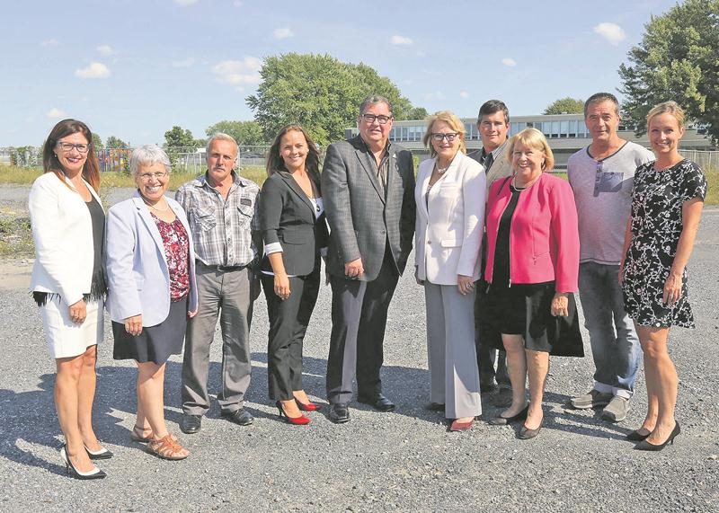 Un centre multisports sera construit sur un terrain adjacent à celui de l’école primaire de La Présentation. Au centre de la photo, le maire de La Présentation, Claude Roger et la députée de Laporte (en veste blanche), Nicole Ménard. Photo Robert Gosselin | Le Courrier ©