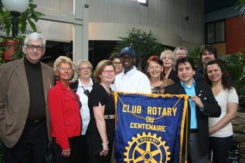 Les membres du Club Rotary de Saint-Hyacinthe encerclent Rodrigue, le fils adoptif de « Maman Nicole » et Nicole Pageau (au centre de la bannière).