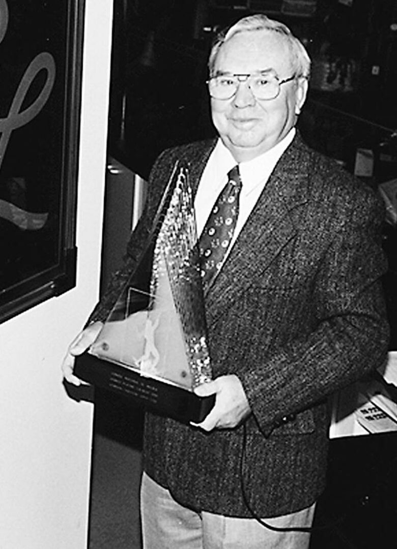 Germain Larivière pose fièrement avec le Trophée Hermès remis par le Conseil national du meuble en 1996.