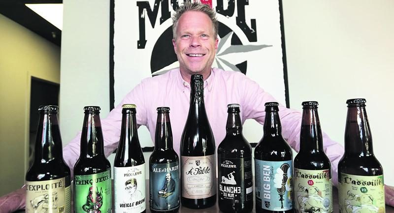 Le président-directeur général de Brasseurs du Monde, Gilles Dubé, affiche un large sourire derrière ses bières médaillées au World Beer Awards. Photo Robert Gosselin | Le Courrier ©