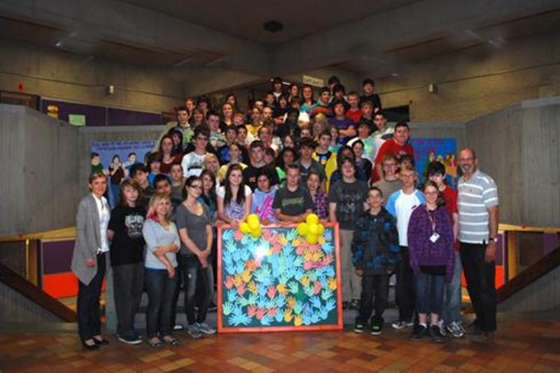 Des élèves d'adaptation scolaire de la Polyvalente Hyacinthe-Delorme sont rassemblés autour de la fresque, juste avant qu'elle soit offerte à l'hôpital Honoré-Mercier.