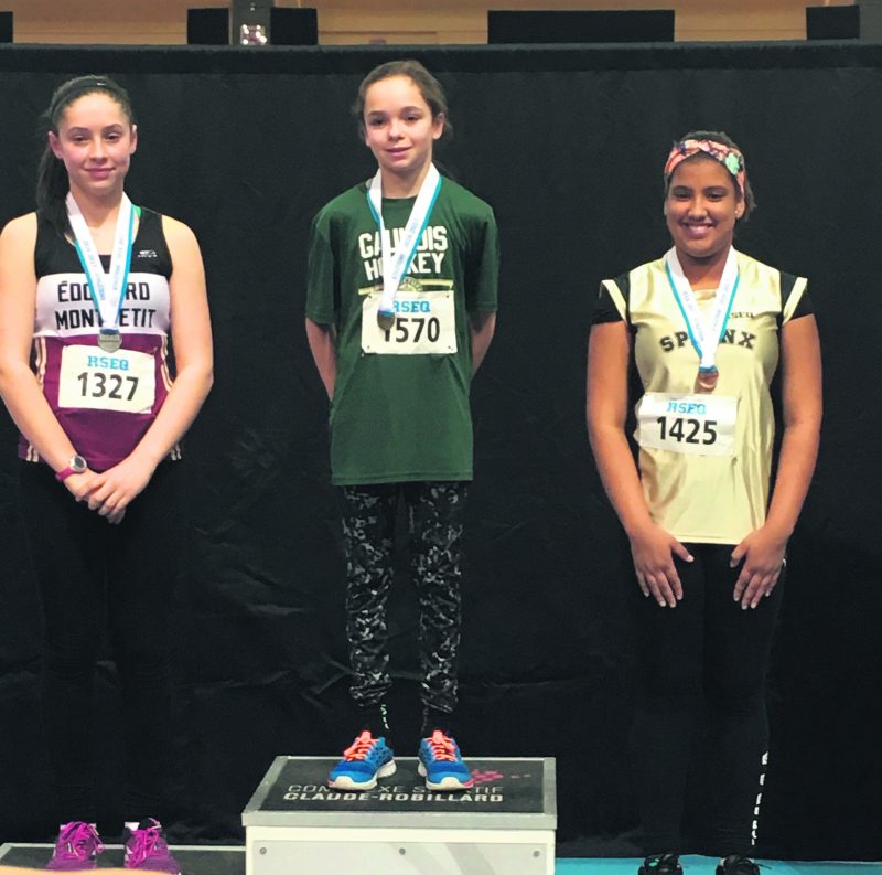 Éloïse Caron (au centre) sur le podium après sa victoire au lancer du poids.  Photo Courtoisie