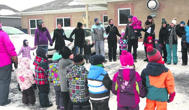 Une chaîne humaine s’est formée devant le Centre de la petite enfance Le temps d’un rêve à Sainte-Madeleine lundi matin afin de dénoncer les compressions qui frappent le réseau des CPE au Québec. Photo Robert Gosselin | Le Courrier ©