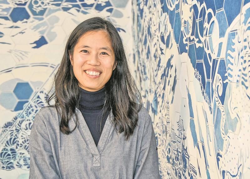 En 2015, Karen Tam a bien résumé à La Presse sa démarche, un « regard sur l’orientalisme et l’exotisme tel que rendu par la culture occidentale ». Elle pose ici devant From Yiwu to you, murale faite en papier cyanotype sensible à la lumière. Photo François Larivière | Le Courrier ©