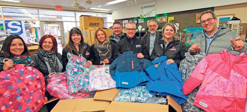 Pierre Beauregard, directeur général de Robert Bernard (au centre), a remis en compagnie de collègues et de bénévoles 250 habits de neige neufs au Centre de Bénévolat de Saint-Hyacinthe. Ceux-ci seront distribués aux enfants de la région provenant de milieux défavorisés pour qu’ils puissent passer un hiver bien au chaud! Photo Robert Gosselin | Le Courrier ©