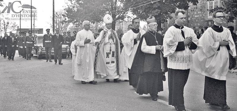 Cortège vers le cimetière de Saint-Pie. Au centre, à gauche, Georges-Édouard Brosseau, curé de Saint-Pie, et Mgr Albert Sanschagrin, évêque du diocèse de Saint-Hyacinthe.