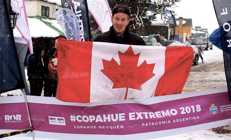 Julien Pinsonneault posant fièrement avec le drapeau canadien au fil d’arrivée de la Copahue Extremo, épreuve de course en raquettes disputée en Argentine, où il a raflé la 1re place au 10 km. Photo courtoisie Copahue Extremo