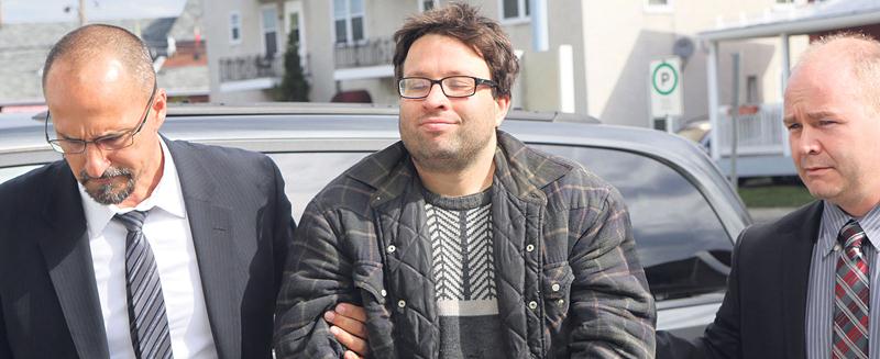 Francis Yergeau, à son arrivée au palais de justice de Saint-Hyacinthe le 19 mai 2016. À gauche, on reconnaît le policier Daniel Fortin, qui a lui-même mené son interrogatoire de 11 heures après l’avoir mis en état d’arrestation. Photothèque | Le Courrier ©