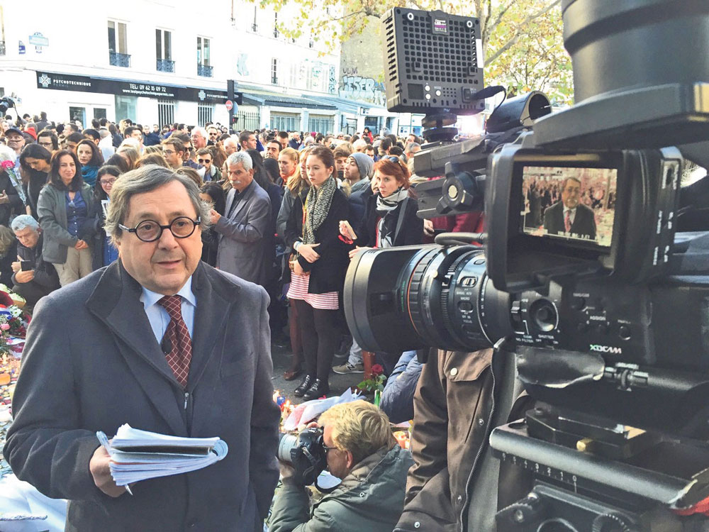Au cours de sa carrière longue de 54 ans, le Maskoutain a couvert plusieurs grands événements qui ont secoué la planète tout entière. Ici, on le voit devant le Bataclan, à Paris, dans les jours qui ont suivi l’attentat meurtrier de 2015. Photo gracieuseté Raymond Saint-Pierre