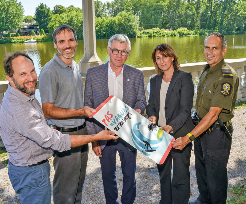 Rémi Gauvin, technicien en environnement à la Ville de Saint-Hyacinthe, David Bousquet, conseiller municipal et responsable du dossier de l’environnement, Claude Corbeil, maire de Saint-Hyacinthe, Salima Hachachena, directrice du service de l’urbanisme, et le policier Mario Côté au moment de lancer la campagne de sensibilisation « Pas de vagues sur nos berges ». Photo François Larivière | Le Courrier ©