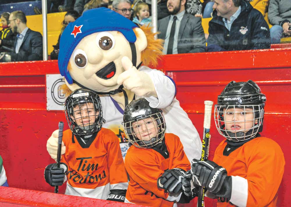La mascotte du Festi-MAHG, Rookie, s’amuse derrière le banc en compagnie des joueurs pendant leur match. Photos François Larivière | Le Courrier ©