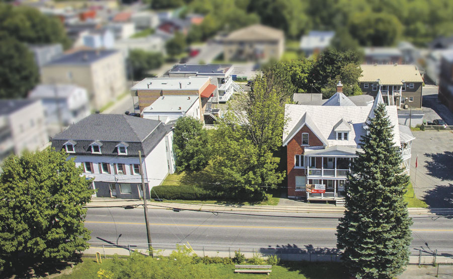 Cette photo prise à vol d’oiseau permet d’apprécier le pâté de maisons du centre-ville où un promoteur de Châteauguay doit construire son projet d’immeuble résidentiel locatif. Le vaste terrain voisin de la Salle Théâtre La Scène se trouve en face de l’école Lafontaine. Photo François Larivière | Le Courrier ©