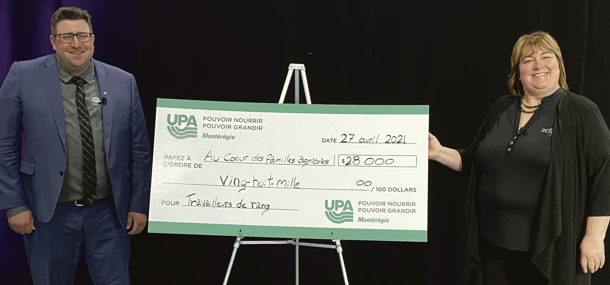 Jérémie Letellier, président de la Fédération de l’UPA de la Montérégie, remet un chèque au montant de 28 000 $ à Nathalie Roy, présidente de l’organisme Au cœur des familles agricoles. Photo gracieuseté