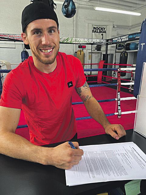 Le boxeur Samuel Lajoie-Déry, tout sourire en signant son contrat en vue de son premier combat chez les professionnels. Photo gracieuseté