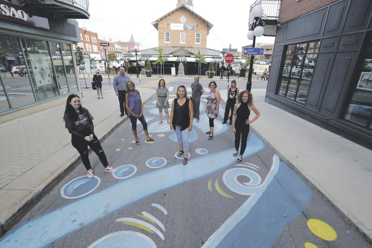 Les artistes qui ont contribué à réaliser les fresques géantes au centre-ville, en compagnie du directeur général de la SDC centre-ville, André Marcotte, que l’on aperçoit à l’arrière gauche. Photo Robert Gosselin | Le Courrier ©
