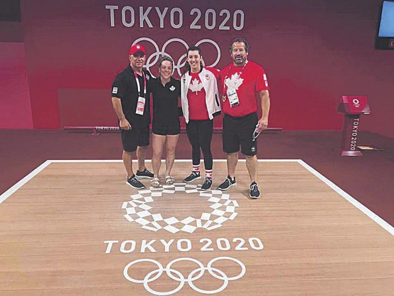 Les haltérophiles Rachel Leblanc-Bazinet et Tali Darisgny sur le plateau de compétition des Jeux olympiques de Tokyo, en compagnie des entraîneurs Yvan Darsigny et Dalas Santavy. Photo Facebook