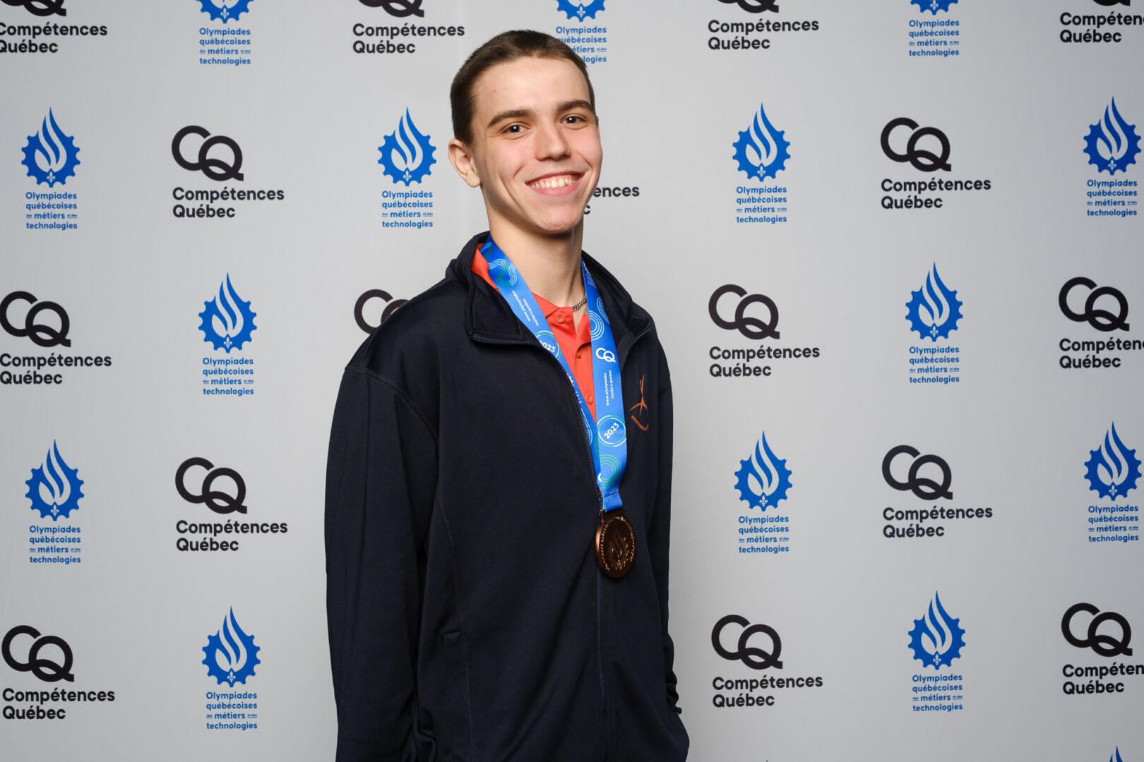 Julio Monange porte fièrement la médaille de bronze pour ses compétences en plâtrage. Photo gracieuseté