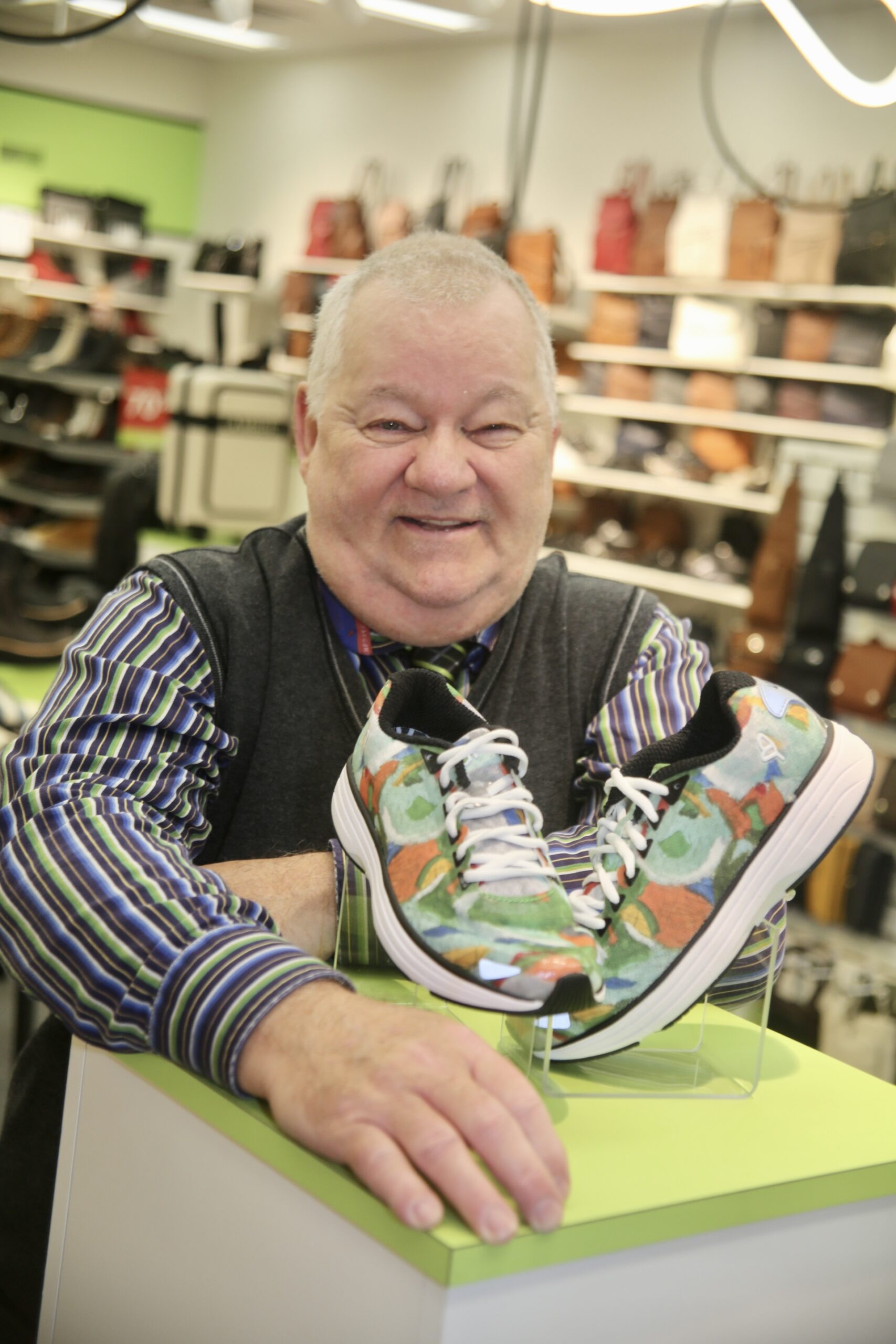 Le 16 octobre, André Bouthat, artiste-peintre vivant avec un trouble de santé mentale et membre du Trait d’union montérégien, s’est vu remettre une paire de chaussures par la boutique Chaussures à vos pieds sur laquelle une de ses toiles a été reproduite. Photo Robert Gosselin | Le Courrier ©