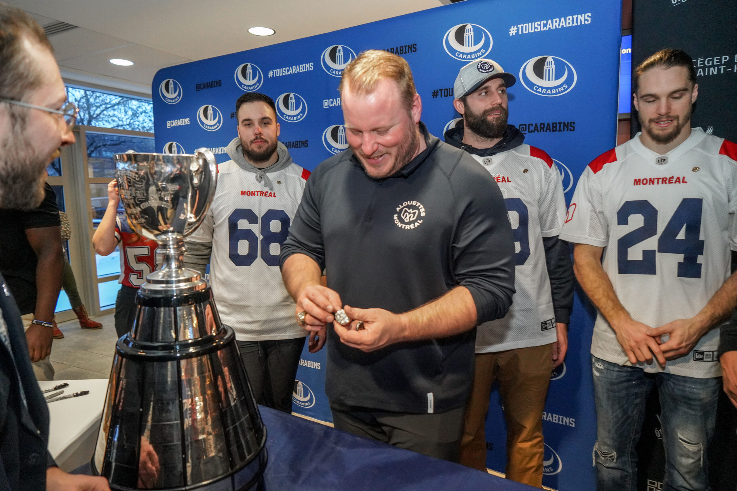 Luc Brodeur-Jourdain, qui a organisé ce rassemblement festif, enfile ses bagues de la Coupe Grey, dont la première qu’il a récoltée à titre d’entraîneur cet automne avec les Alouettes de Montréal. Photo François Larivière | Le Courrier ©