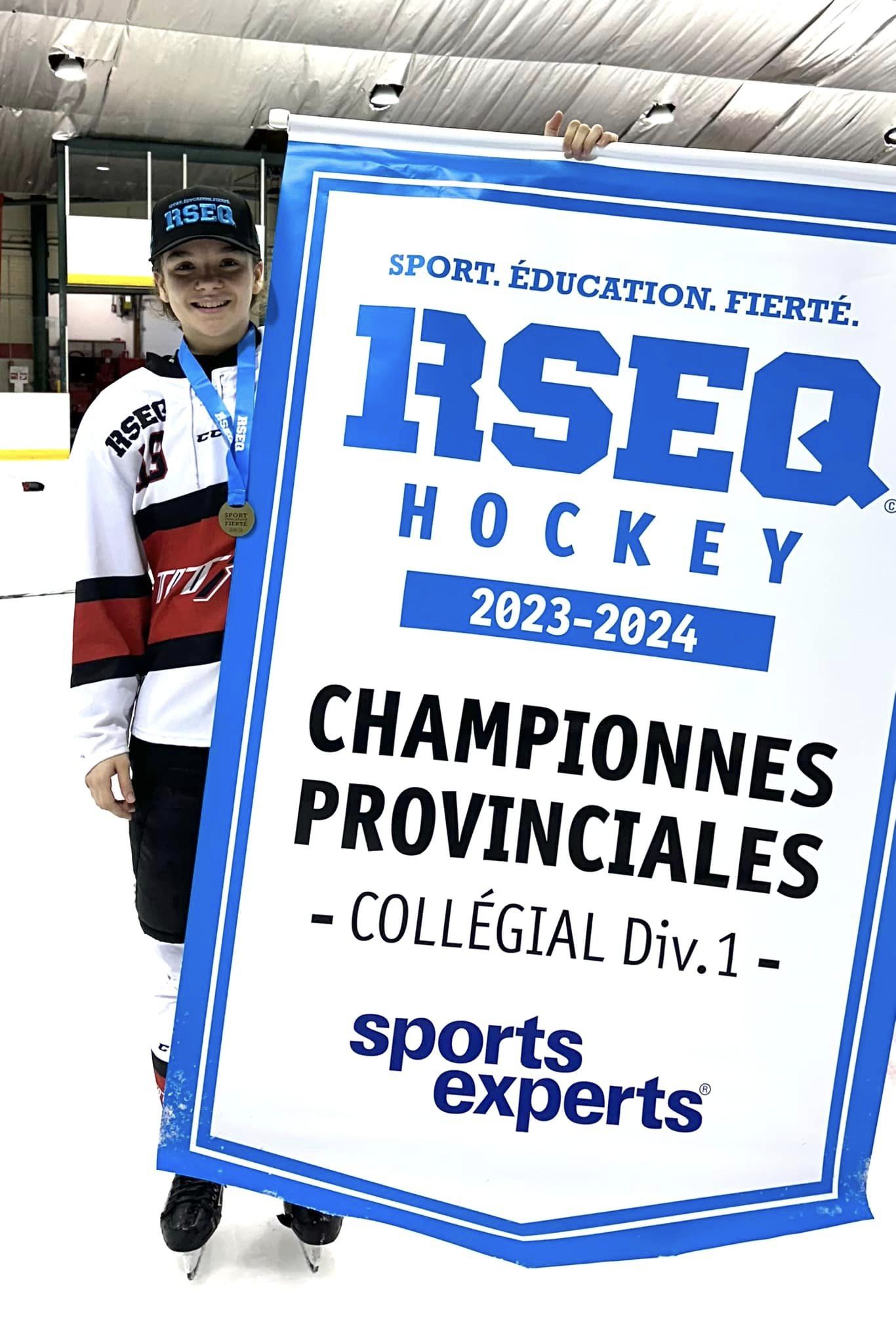 Éloïse Caron pose avec sa médaille d’or et la bannière de championnes provinciales remportée par les Titans du Cégep de Limoilou. Photo gracieuseté