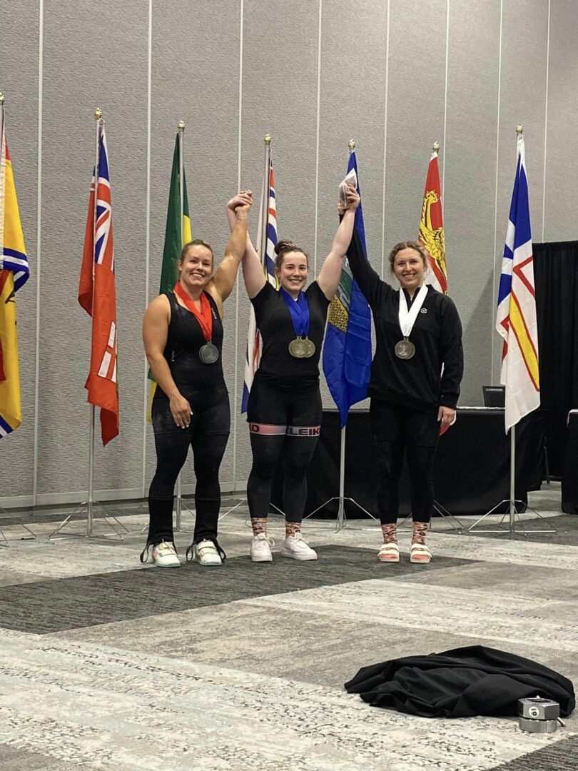 Charlotte Simoneau (au centre) a remporté l’or chez les 71 kg au championnat canadien senior, en plus d’être la meilleure leveuse chez les femmes toutes catégories confondues. On la voit entourée d’Alexis Ashworth (à gauche) et d’Andréann Lamarre (à droite), une autre membre de La Machine Rouge, qui ont complété le podium. Photo gracieuseté