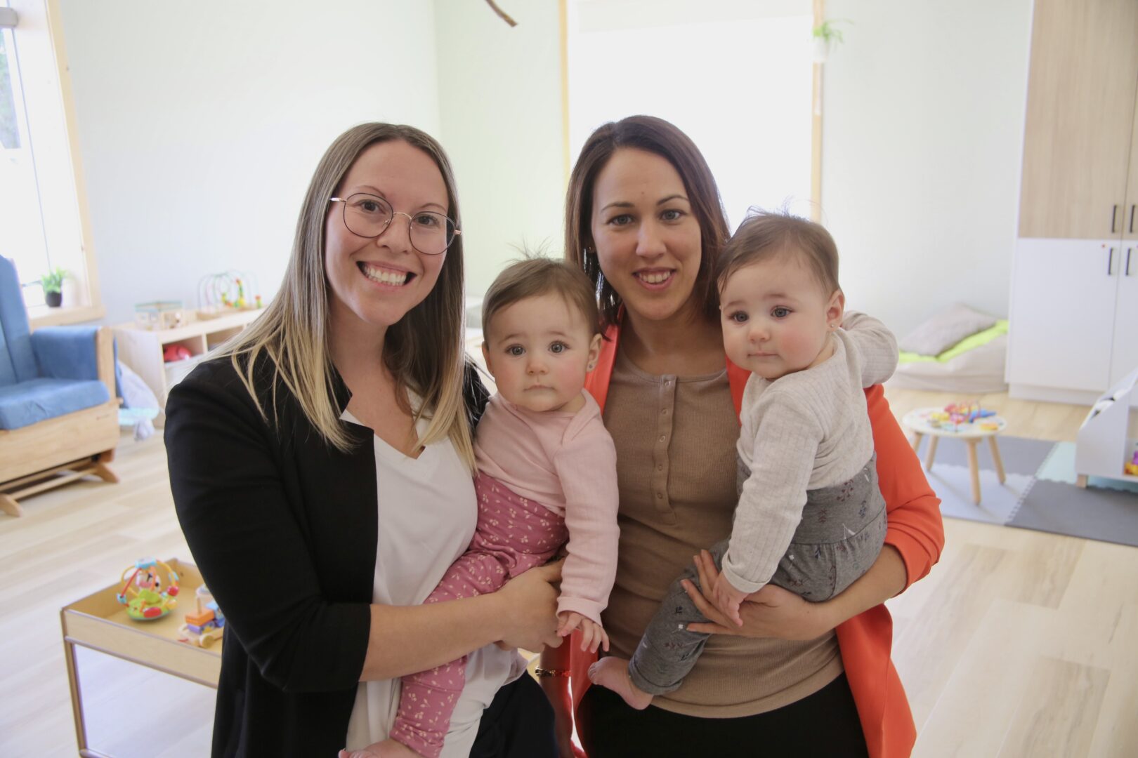 La propriétaire de la garderie Le Zirafo en nature, Sabrina Nault, et la directrice générale adjointe de l’installation, Karine Auger, dans une des pouponnières avec les jumelles Raphaëlle et Emmaly Duquette âgées de 8 mois. Photo Robert Gosselin | Le Courrier ©