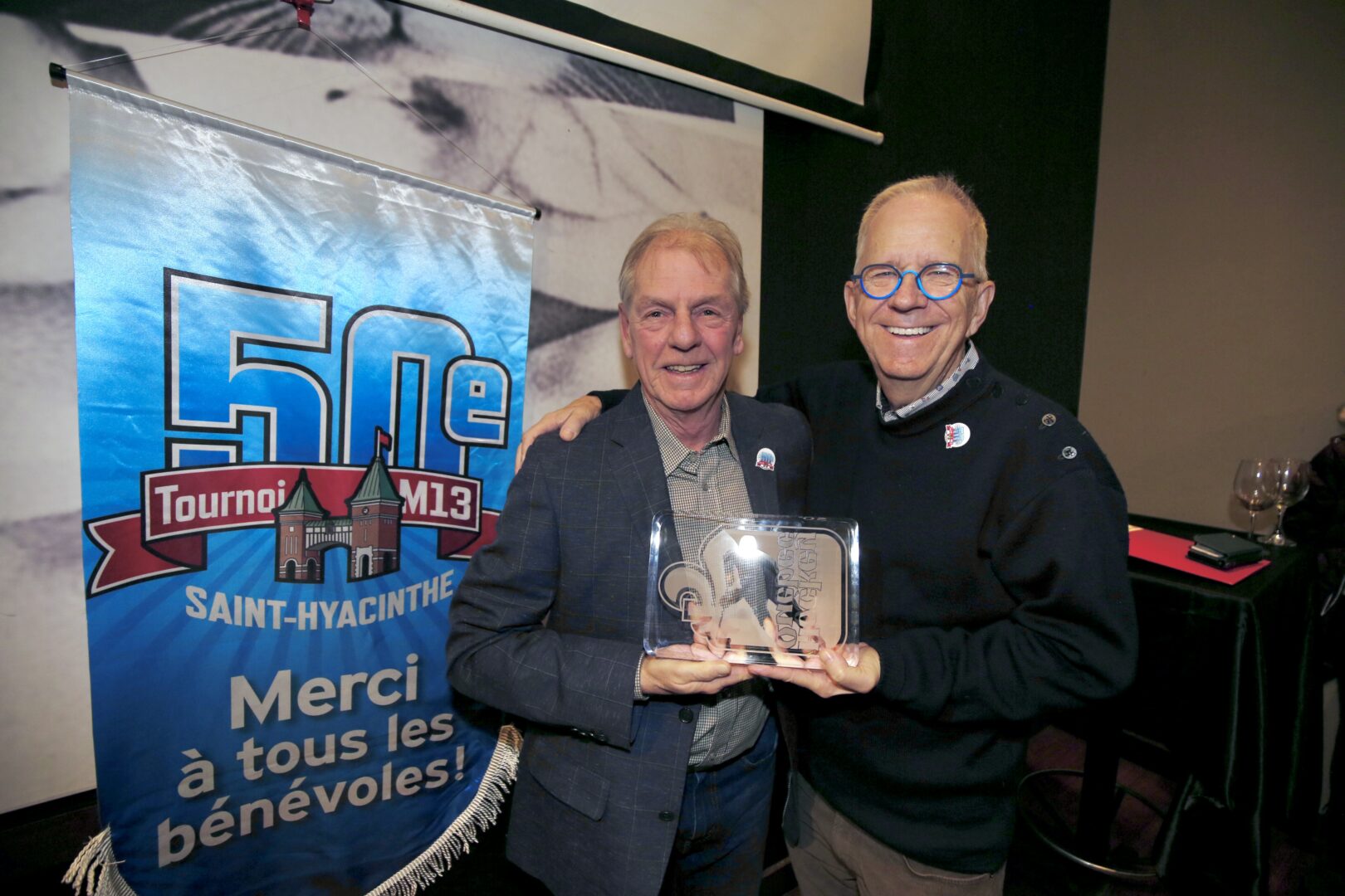 Une plaque soulignant la longévité du Tournoi national de hockey M13 de Saint-Hyacinthe a été remise au président du comité organisateur, Lucien Beauregard, par le représentant de Hockey Richelieu, Denis Proulx . Photo Robert Gosselin | Le Courrier ©