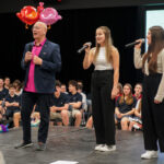 L’enseignant derrière le projet, Sylvain Bossé, interprétant la chanson thème avec les élèves Mila et Audrey. Photo François Larivière | Le Courrier ©